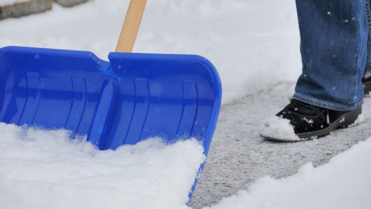 Frau beim Schneeschaufeln
