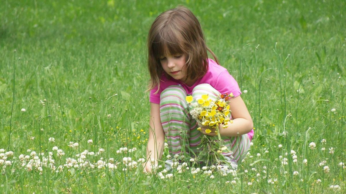 Mädchen mit Blumenstrauß auf Wiese