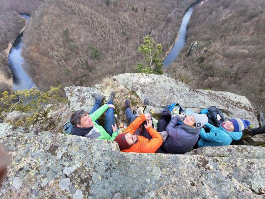 4 Menschen sitzen auf einem Felsvorsprung hoch über dem Thayatal.