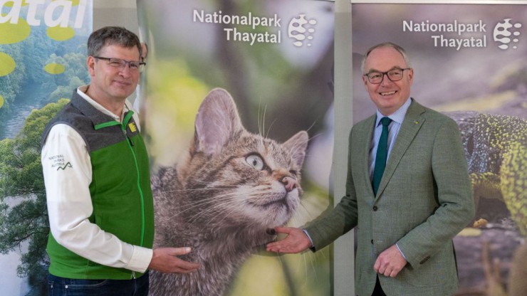 Christian &Uuml;bl und Stephan Pernkopf stehen vor einem Rollup mit dem Portr&auml;t einer Wildkatze